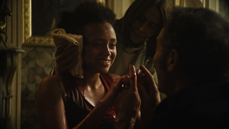 Characters sitting at a table in a dimly lit room